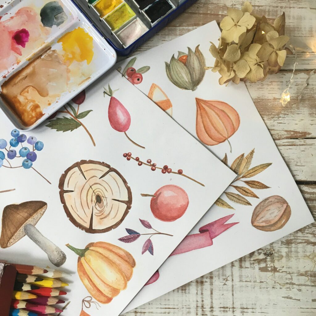 image if fall themed watercolor painting in browns and oranges on light wood background